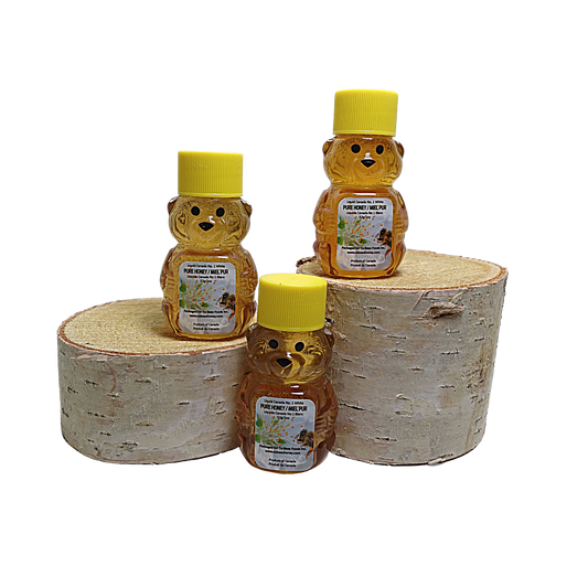 Three 2 oz miniature bear honey containers with yellow lids on a white background