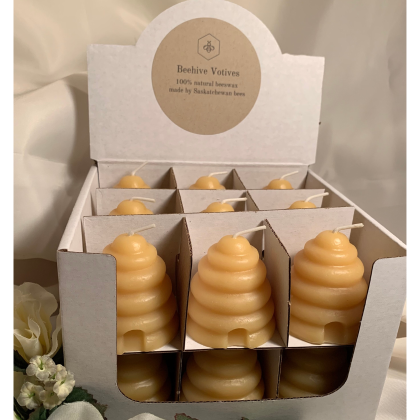 18 Beeswax beehive shaped votives in a cardboard display.  Handmade and poured in small batches. 100% Canadian made.