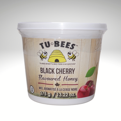 A 375g Tub of Tu-Bees Black Cherry flavoured honey with a white background