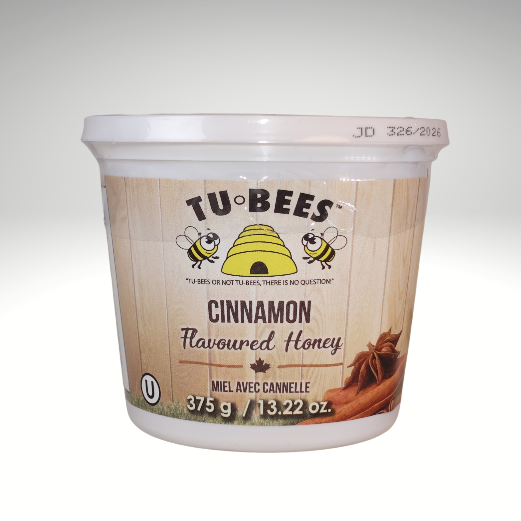 A 375g tub of Tu-Bees Cinnamon flavoured honey on a white background