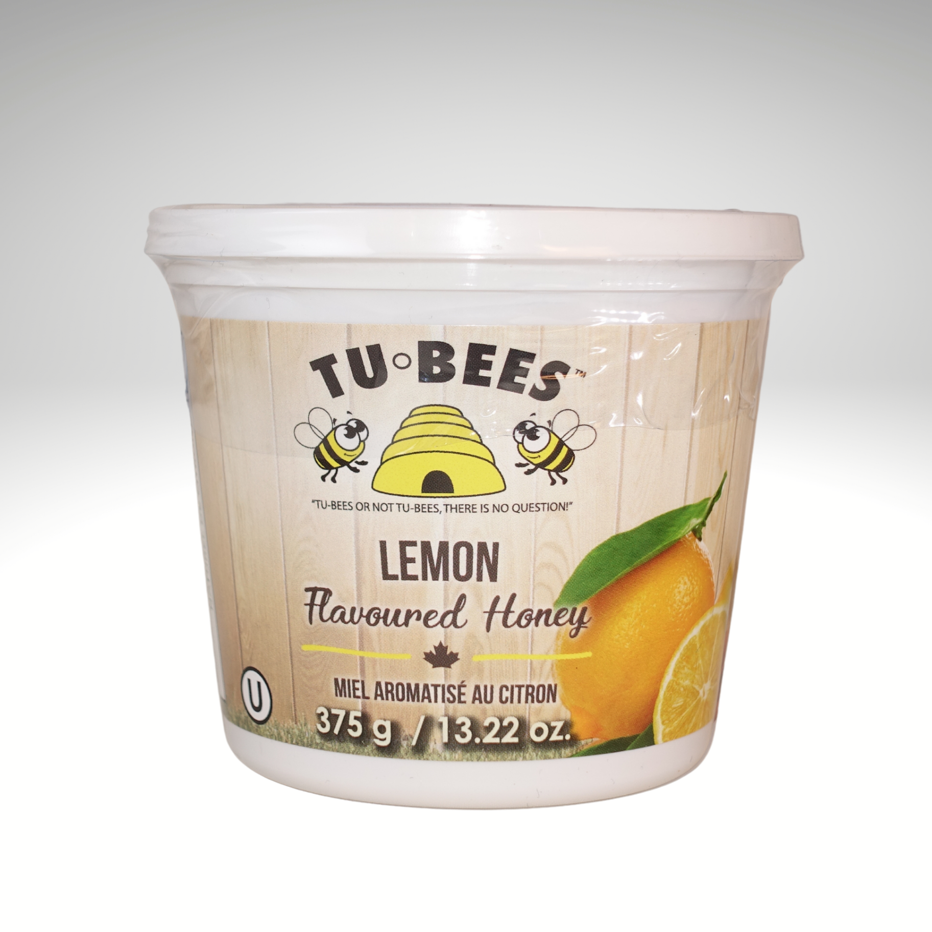 A 375g tub of Tu-Bees Lemon flavoured honey, OU Kosher, Product of Canada, on a white background